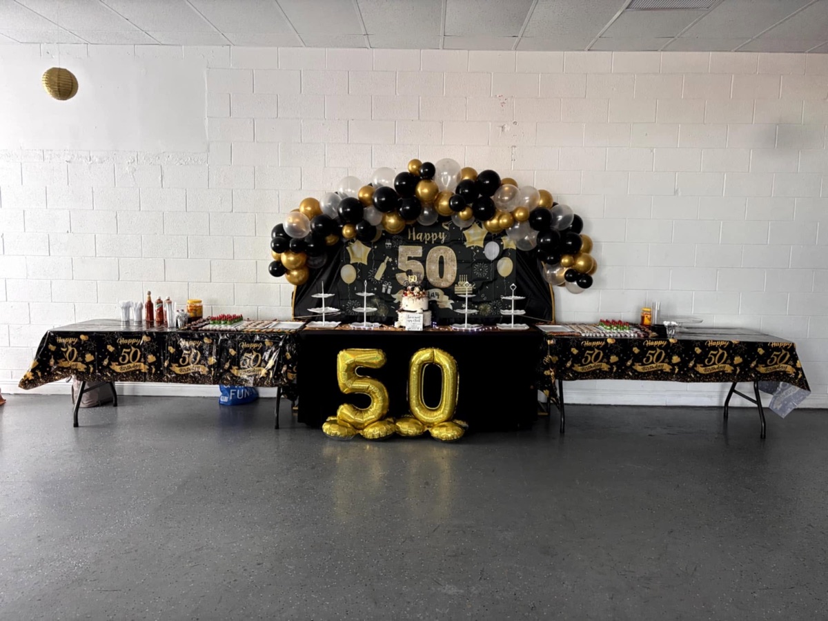 A black and gold dessert table set for a fiftieth birthday