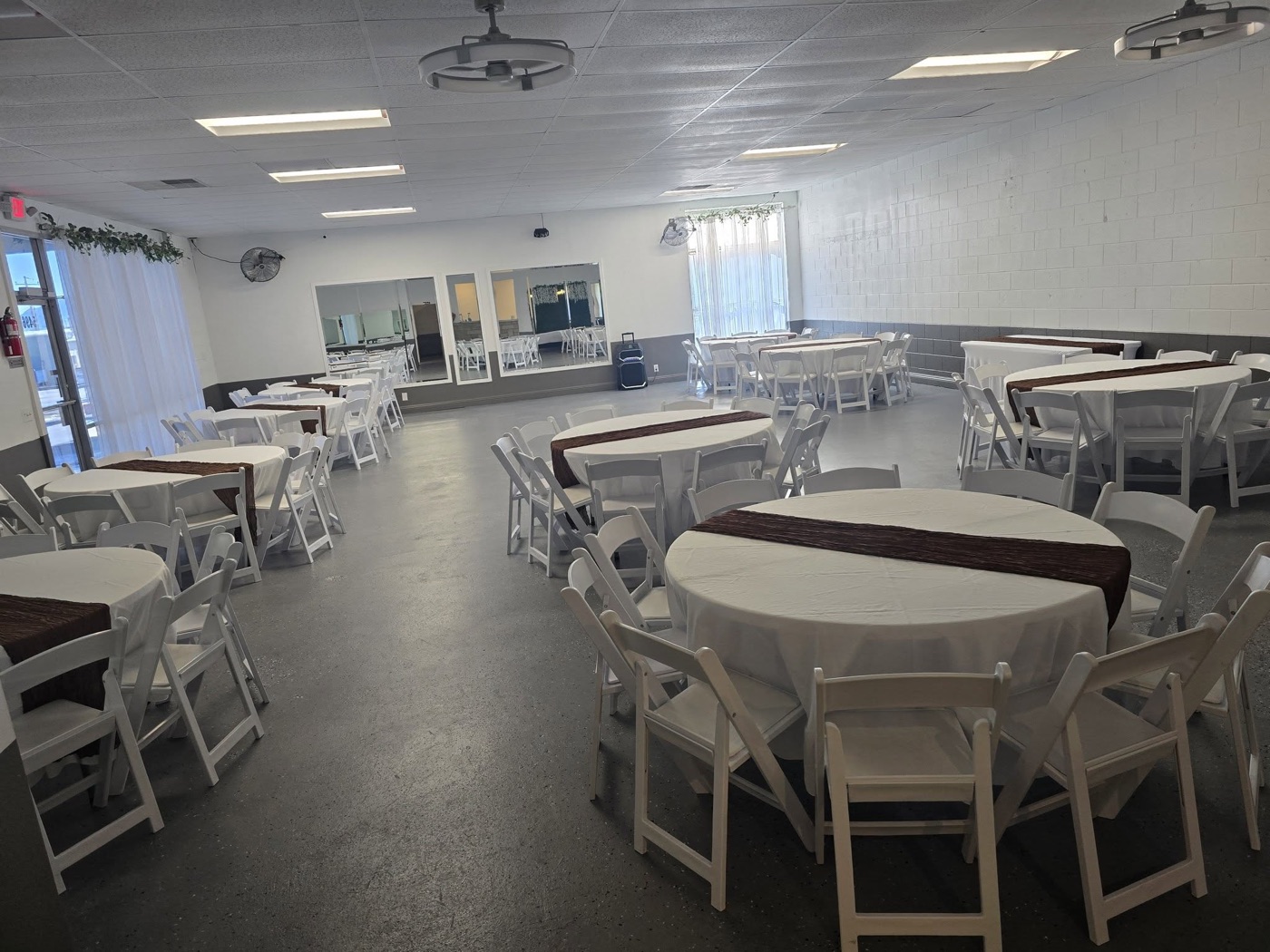 The hall set with round tables and chocolate runners under warm light