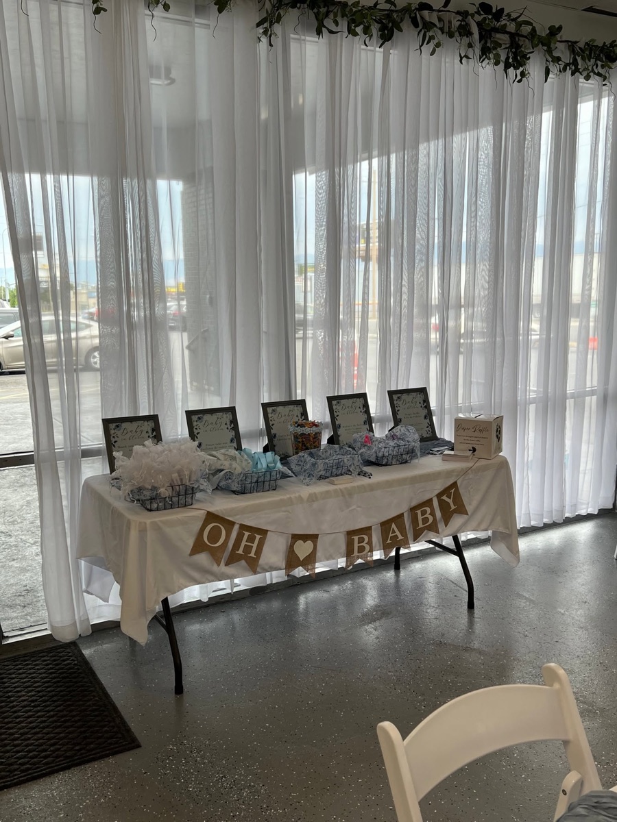 A welcome table set by the sheer curtained front windows at Epic Venue Event Center in Kearns