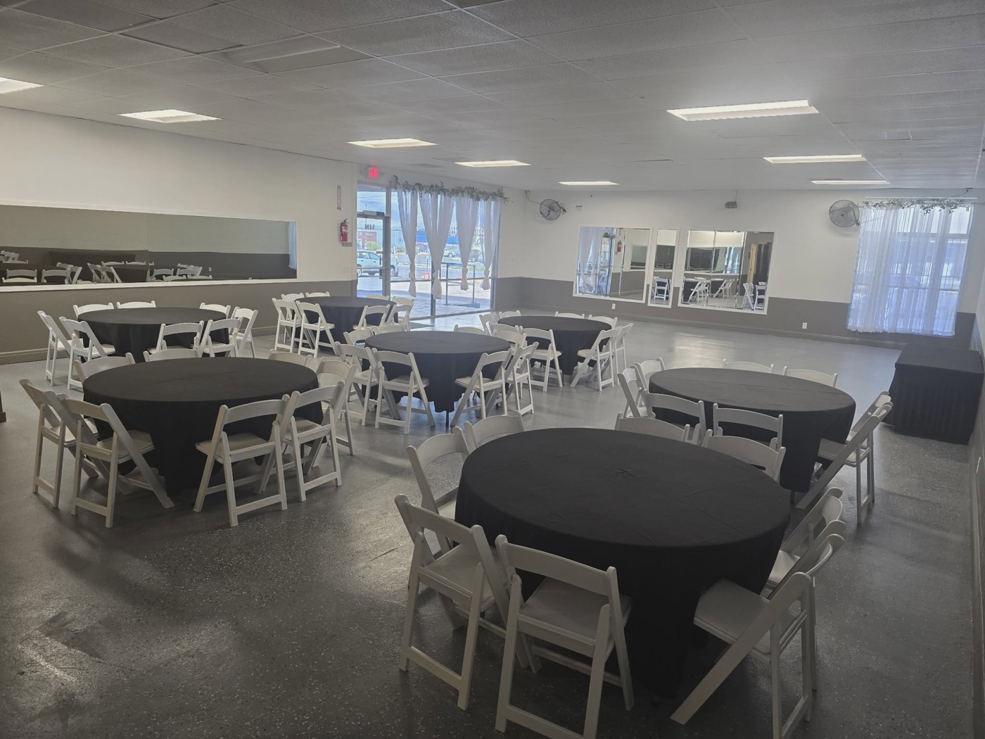 The open hall with its wall to wall mirrors and a small stage, ready to set up
